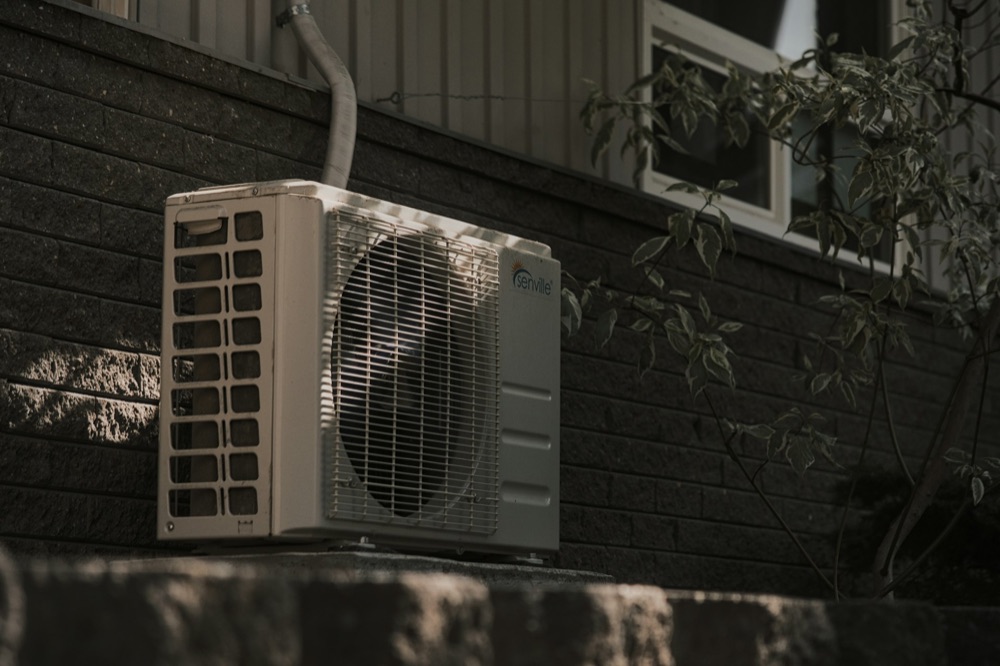 Central air conditioner condenser unit installed outside a London home